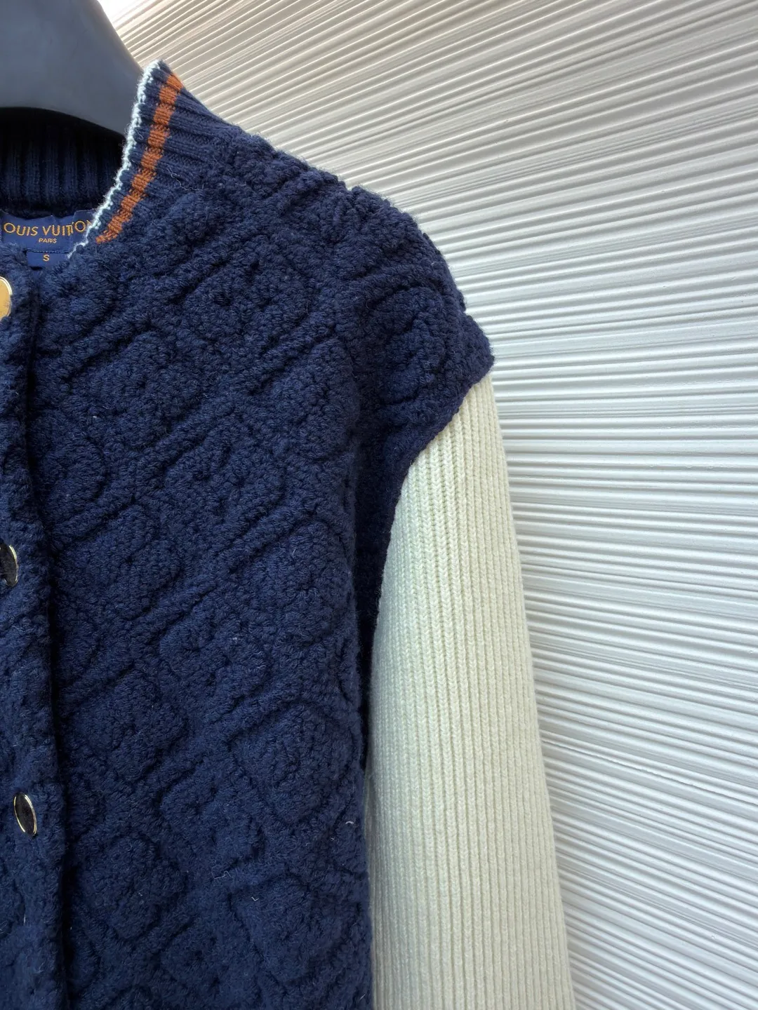 LOUIS VUITTON SKI ski series color-blocked striped baseball long-sleeved jacket ●Original version: purchased and developed for 22999 ●Item number: 1682091-D35 ●Fabric: wool blended fabric ●Technology: knitted ●Color: blue and white ●Version: fitted version ●Weight: about 1070 grams ●Size: S-M-L-XL ●Description: This Louis Vuitton color-blocked knitted cardigan uses a three-dimensional cable knitting process to create the main body. It uses high-count merino wool blended fabrics and uses a double needle bed knitting machine to create a concave and convex rhombus texture. The knitting density reaches 32 needles per square centimeter, making the texture both three-dimensional and soft. The main body of the body is made of navy blue fixed-spun yarn, which has been washed and fixed three times to effectively prevent fading. The sleeves are made of off-white vertical pit rib knitting, and the single-strand yarn twist is controlled at 800 twists/meter to ensure resilience and fit. The metal snaps are made of custom-made brass and have been treated with gold-plated glaze sealing. The contrasting ribs on the collar and hem are intarsia woven, accurately matching the proportions of the brand's classic three-color webbing. The cuffs also have a hidden laser-engraved brand logo. The overall process combines traditional knitting techniques with modern precision, and the details are full of craftsmanship. The overall wiring is straight and delicate, the fabric is comfortable and soft, and the color is consistent without color difference. It can be matched with the same style to create a fashionable look and control various occasions. Customized accessories, complete with three standards, same style for men and women!